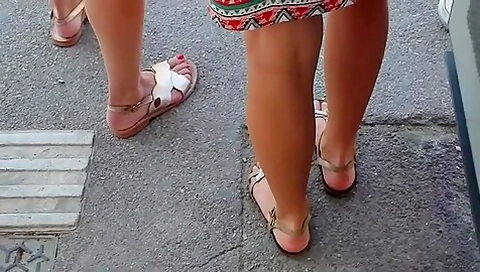Beautiful Legs And Feet In Sandals Of Two Attractive Young Women